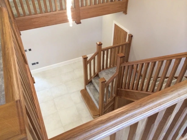 Handcrafted oak staircase with carpet finish and matching balustrade installed by Springfield Stairs in Swadlincote home